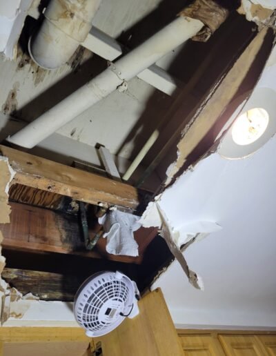 Ceiling opened below a bathroom to trace a water leak in Germantown, MD