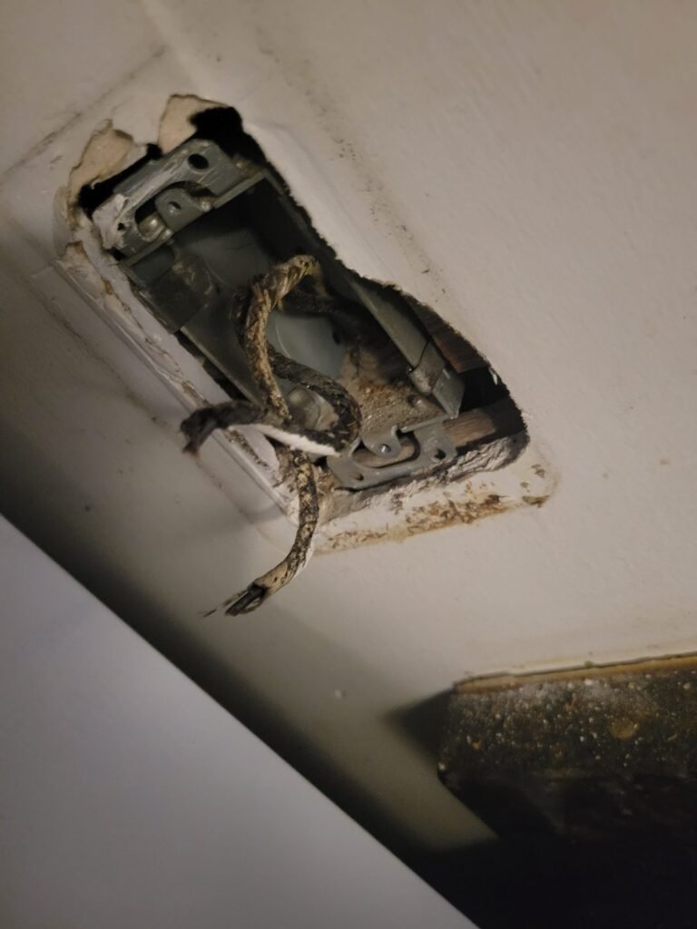 Damaged electrical outlet box before repair in Washington, DC