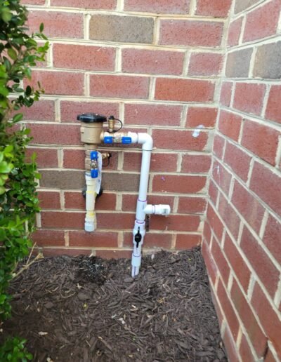 Backflow preventer installed against a brick wall in Severn, MD