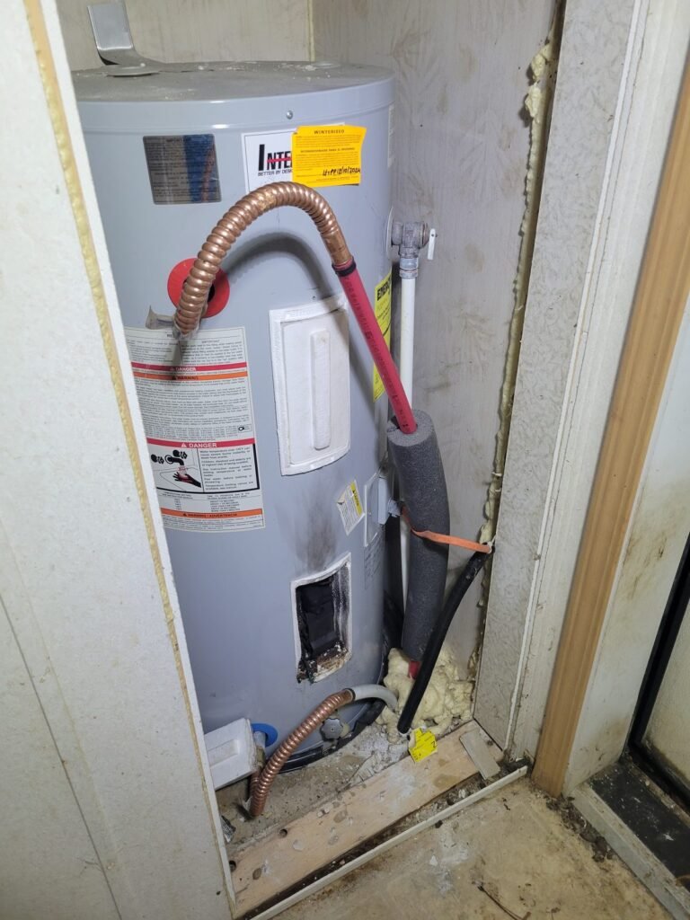 Old electric water heater in a closet with corroded connections before replacement in Dunkirk, MD